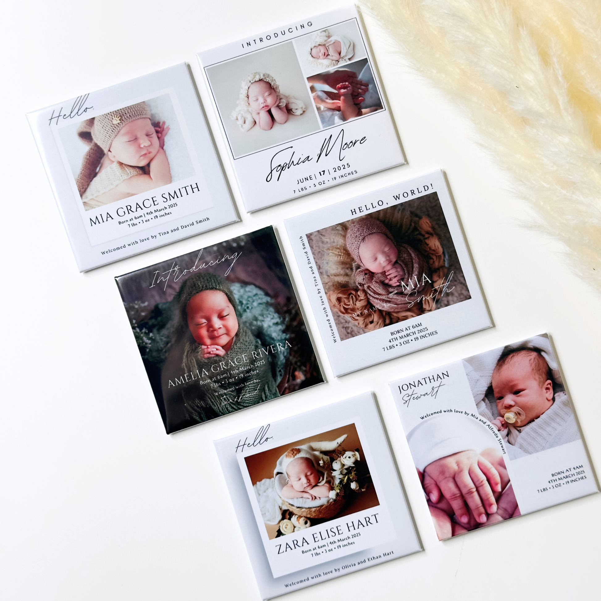 Collection of baby photo cards with names and photos on a white surface.